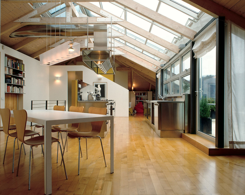 Immagine di un ampio soggiorno design stile loft con parquet chiaro e pareti bianche