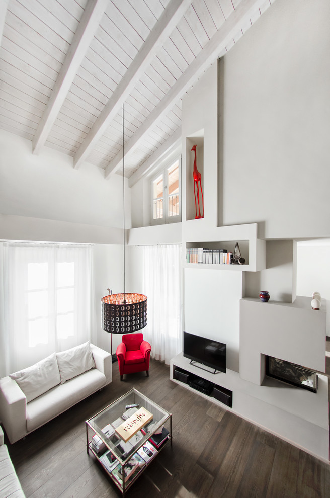 На фото: двухуровневая гостиная комната среднего размера в современном стиле с серыми стенами, темным паркетным полом, двусторонним камином, фасадом камина из штукатурки, отдельно стоящим телевизором и коричневым полом