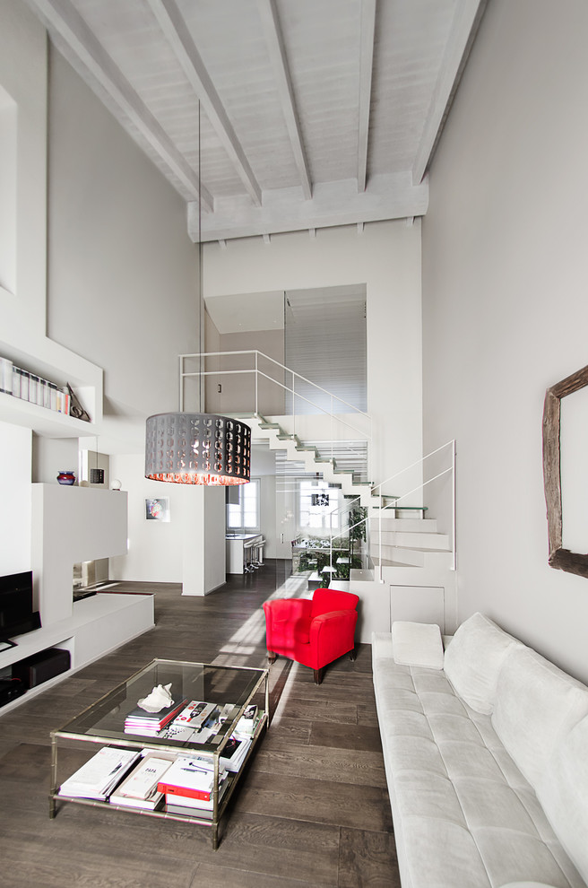 Идея дизайна: двухуровневая гостиная комната среднего размера в современном стиле с серыми стенами, темным паркетным полом, двусторонним камином, фасадом камина из штукатурки, отдельно стоящим телевизором и коричневым полом