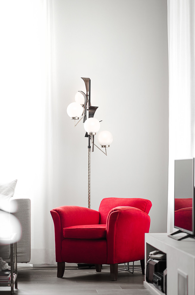 Свежая идея для дизайна: двухуровневая гостиная комната среднего размера в стиле ретро с серыми стенами, темным паркетным полом, двусторонним камином, фасадом камина из штукатурки, отдельно стоящим телевизором и коричневым полом - отличное фото интерьера