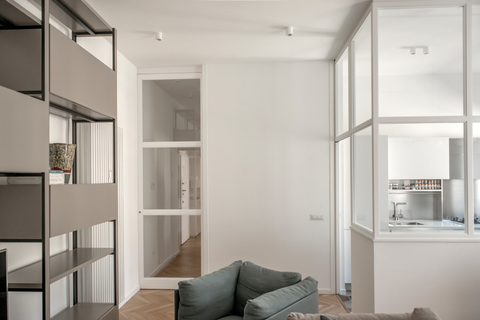 Idee per un soggiorno minimal di medie dimensioni e aperto con libreria, pareti bianche, pavimento in legno massello medio, TV autoportante e pavimento marrone