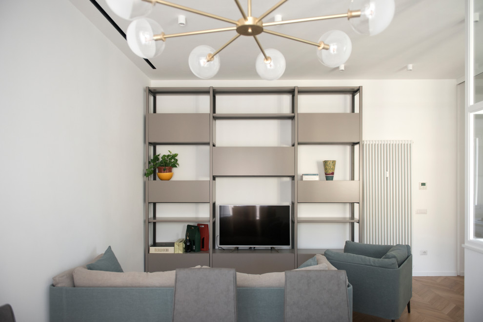 Esempio di un soggiorno contemporaneo di medie dimensioni e aperto con libreria, pareti bianche, pavimento in legno massello medio, TV autoportante e pavimento marrone