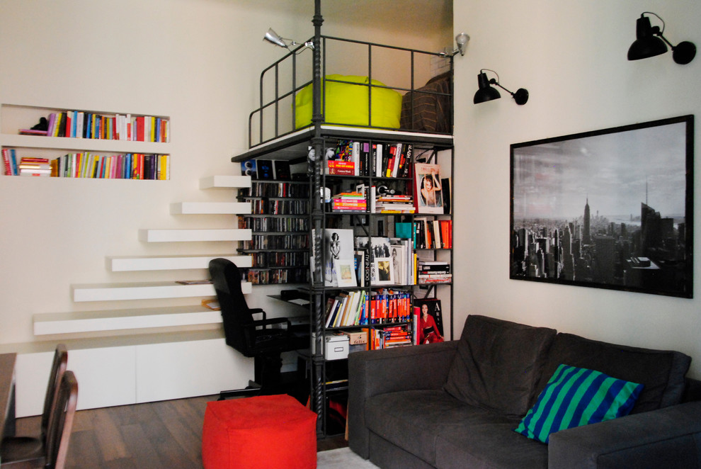 Kleines Industrial Wohnzimmer mit weißer Wandfarbe und dunklem Holzboden in Mailand