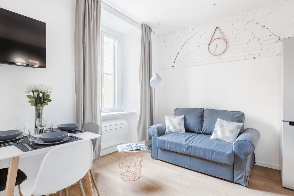 Cette image montre un petit salon design ouvert avec un mur blanc, sol en stratifié et un sol beige.