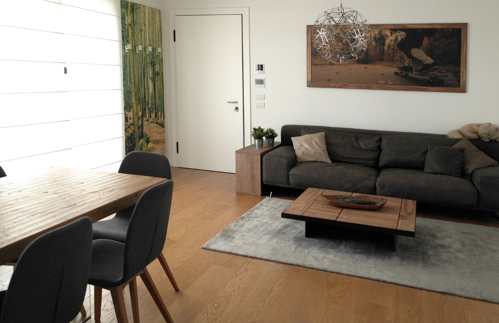 Immagine di un piccolo soggiorno contemporaneo stile loft con pareti bianche, parquet chiaro, TV a parete e pavimento marrone