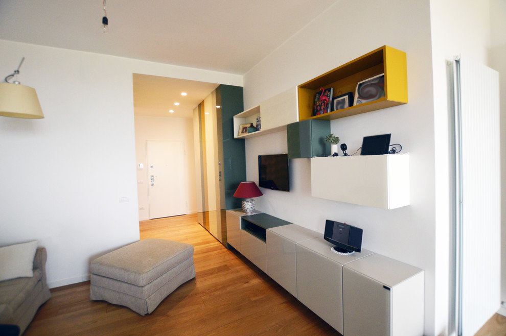 Exempel på ett stort minimalistiskt separat vardagsrum, med ett bibliotek, vita väggar, ljust trägolv, en väggmonterad TV och brunt golv