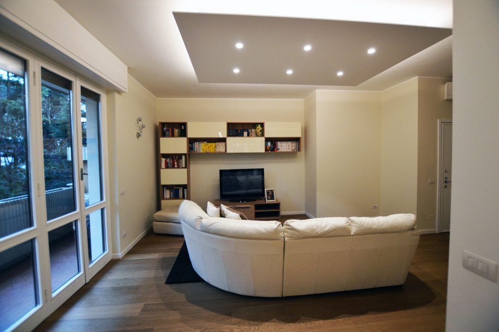Großes, Offenes Modernes Wohnzimmer mit beiger Wandfarbe, dunklem Holzboden, Tunnelkamin, verputzter Kaminumrandung und braunem Boden in Mailand