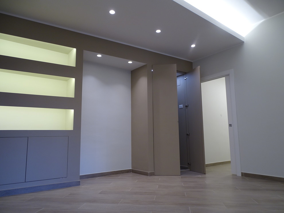 Идея дизайна: открытая гостиная комната в современном стиле с с книжными шкафами и полками, коричневыми стенами и полом из керамогранита