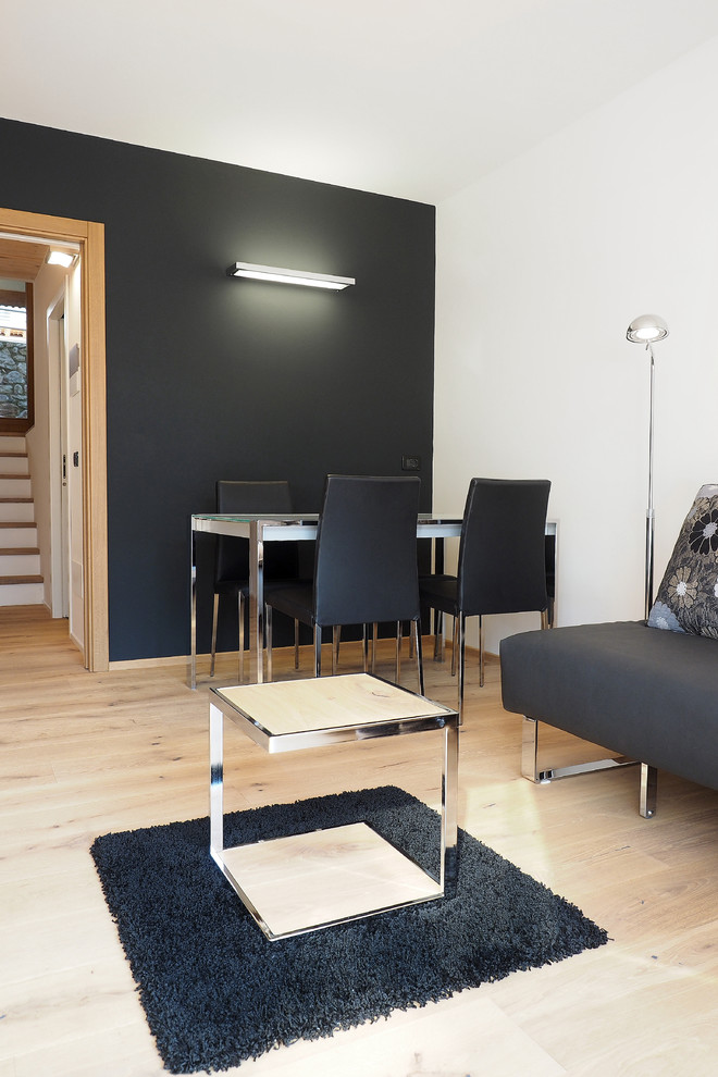 На фото: изолированная гостиная комната в современном стиле с черными стенами и светлым паркетным полом