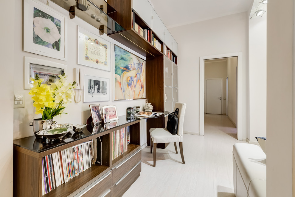 Imagen de sala de estar abierta moderna pequeña con paredes beige, suelo laminado, televisor independiente y suelo beige