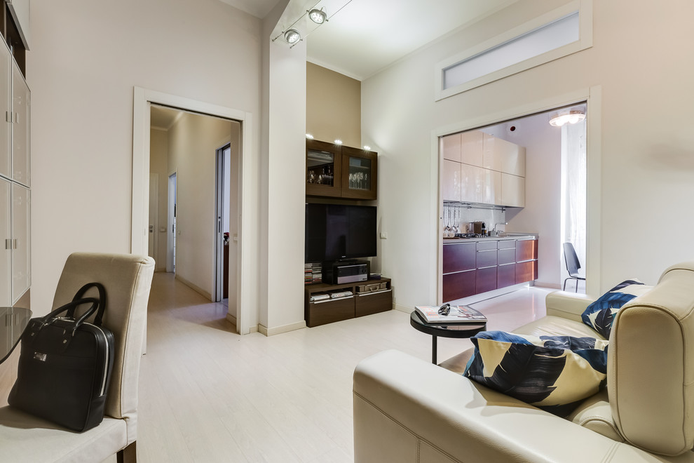 Esempio di un piccolo soggiorno minimalista aperto con pareti beige, pavimento in laminato, TV autoportante e pavimento beige