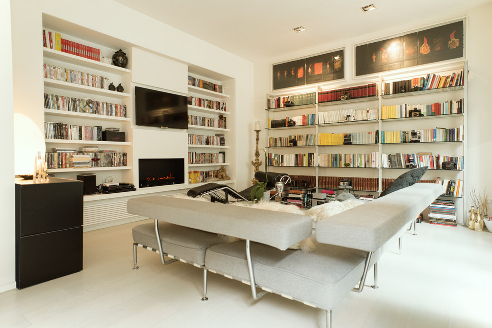 Идея дизайна: изолированная гостиная комната среднего размера в современном стиле с с книжными шкафами и полками, белыми стенами, горизонтальным камином, фасадом камина из штукатурки, телевизором на стене, белым полом и деревянным полом