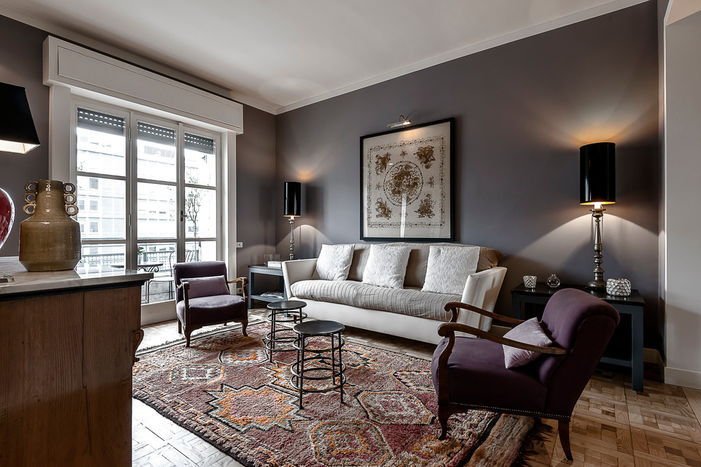 This is an example of a traditional living room in Milan with grey walls and light hardwood flooring.