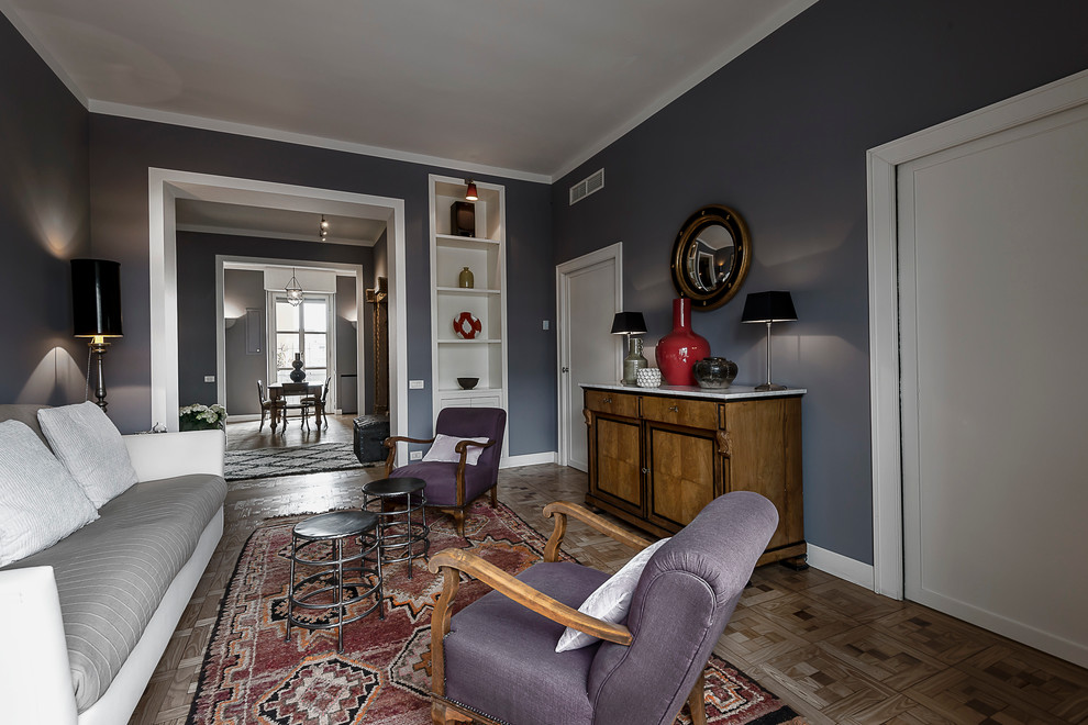 Aménagement d'un grand salon éclectique avec un mur gris, un sol en bois brun et un manteau de cheminée en plâtre.