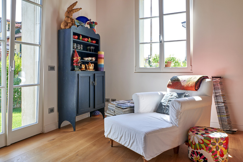 Cette photo montre une salle de séjour chic de taille moyenne et ouverte avec un mur blanc, un sol en bois brun, aucun téléviseur et un sol marron.