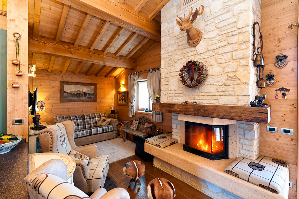 Réalisation d'un salon chalet avec parquet foncé, une cheminée standard et un manteau de cheminée en pierre.