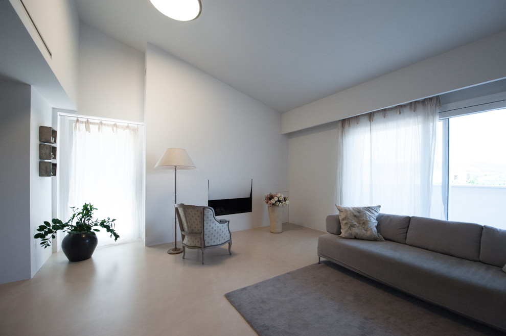 Ispirazione per un grande soggiorno minimalista stile loft con pareti bianche, cornice del camino in intonaco, TV a parete e pavimento beige