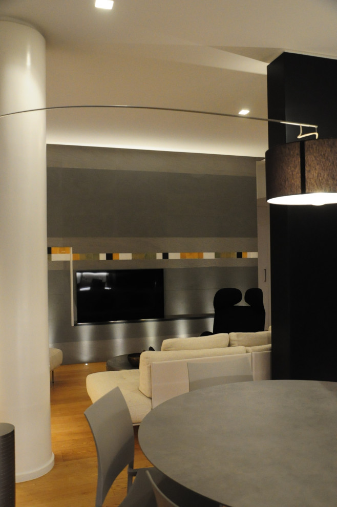 Идея дизайна: открытая гостиная комната среднего размера в современном стиле с серыми стенами, светлым паркетным полом и телевизором на стене