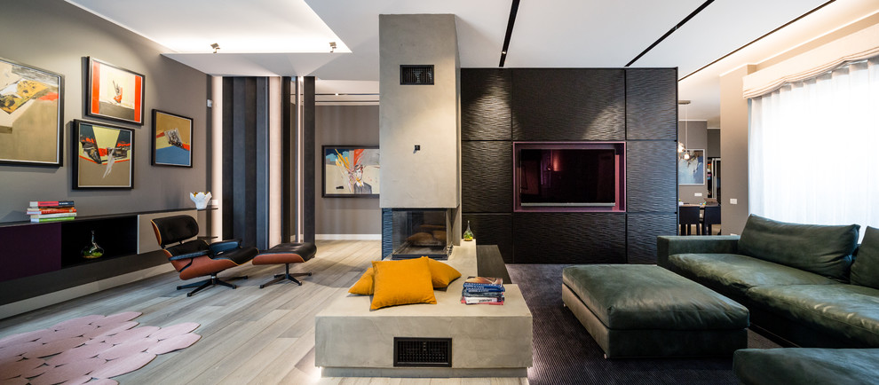 Geräumiges, Offenes Eklektisches Wohnzimmer mit schwarzer Wandfarbe, dunklem Holzboden, Tunnelkamin, Kaminumrandung aus Beton, TV-Wand und grauem Boden in Mailand