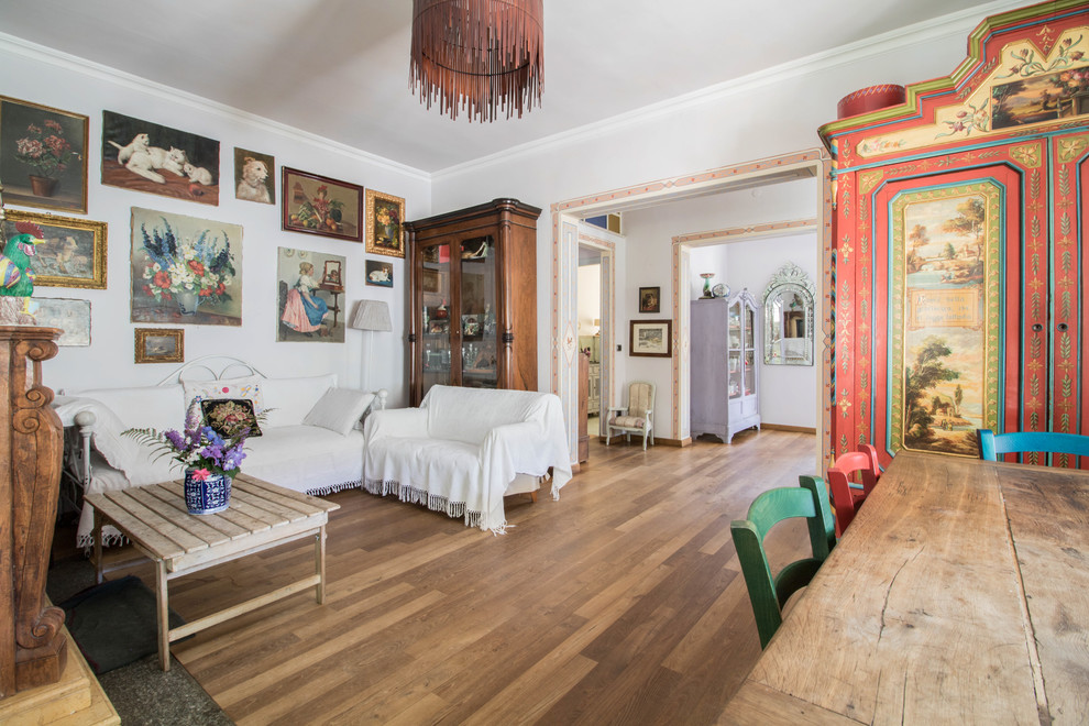 Abgetrenntes Country Wohnzimmer mit weißer Wandfarbe, braunem Holzboden und braunem Boden in Sonstige