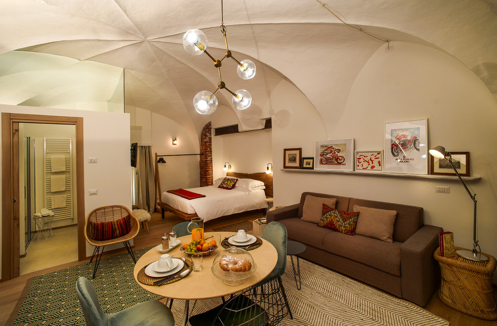 Immagine di un piccolo soggiorno minimal stile loft con pareti bianche, pavimento in legno verniciato, nessun camino e TV a parete
