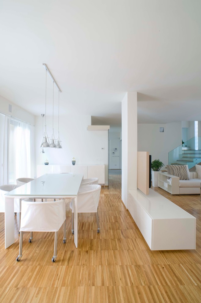 Diseño de salón abierto contemporáneo de tamaño medio con paredes blancas y suelo de madera clara