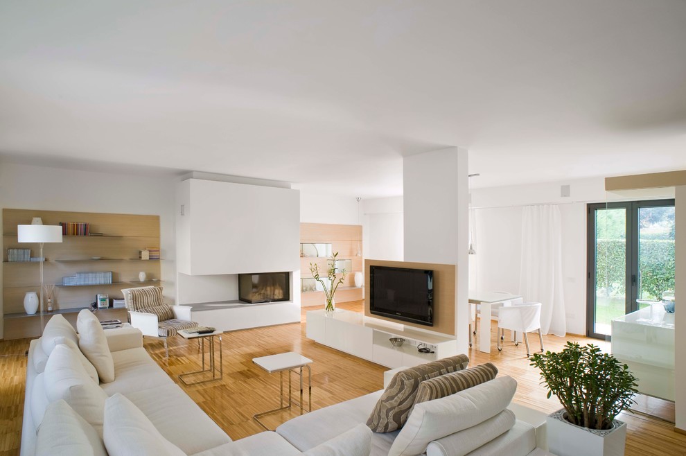 На фото: открытая гостиная комната среднего размера в современном стиле с белыми стенами, светлым паркетным полом, горизонтальным камином, фасадом камина из штукатурки и телевизором на стене
