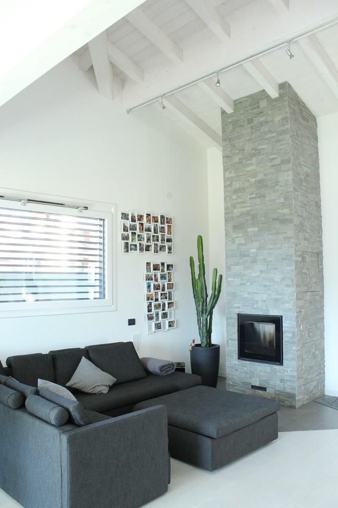 Foto de sala de estar abierta contemporánea grande con paredes blancas, suelo de baldosas de porcelana, chimenea lineal, marco de chimenea de piedra y televisor retractable