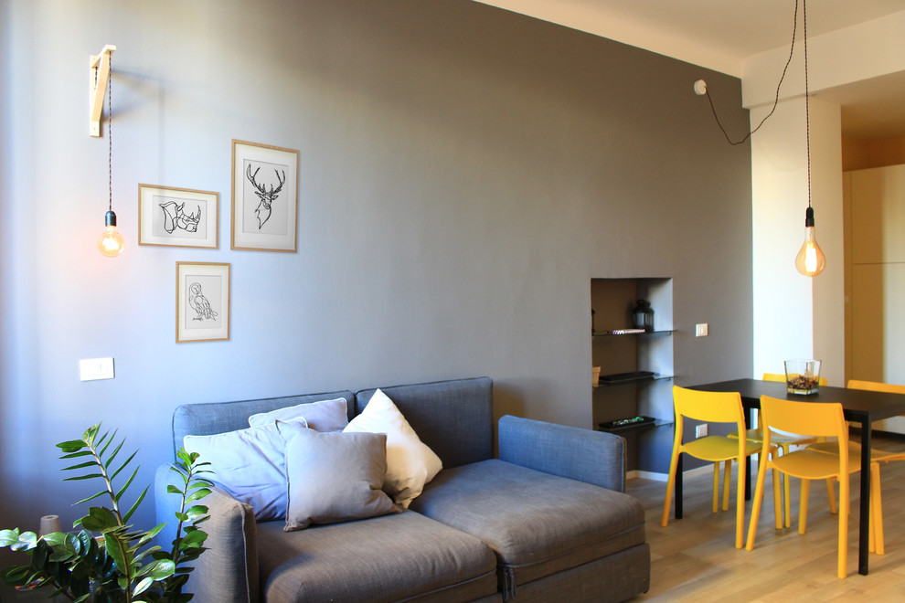 Esempio di un piccolo soggiorno scandinavo aperto con pareti grigie, pavimento in laminato e TV a parete