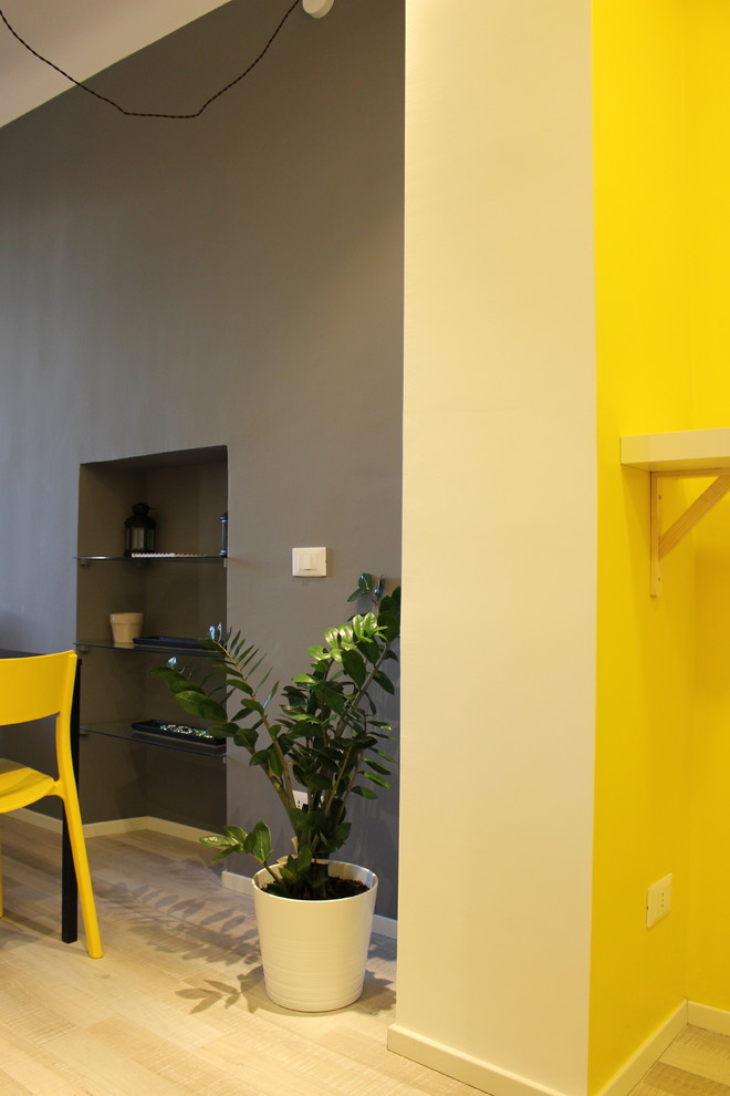 Aménagement d'un petit salon scandinave ouvert avec un mur jaune et sol en stratifié.