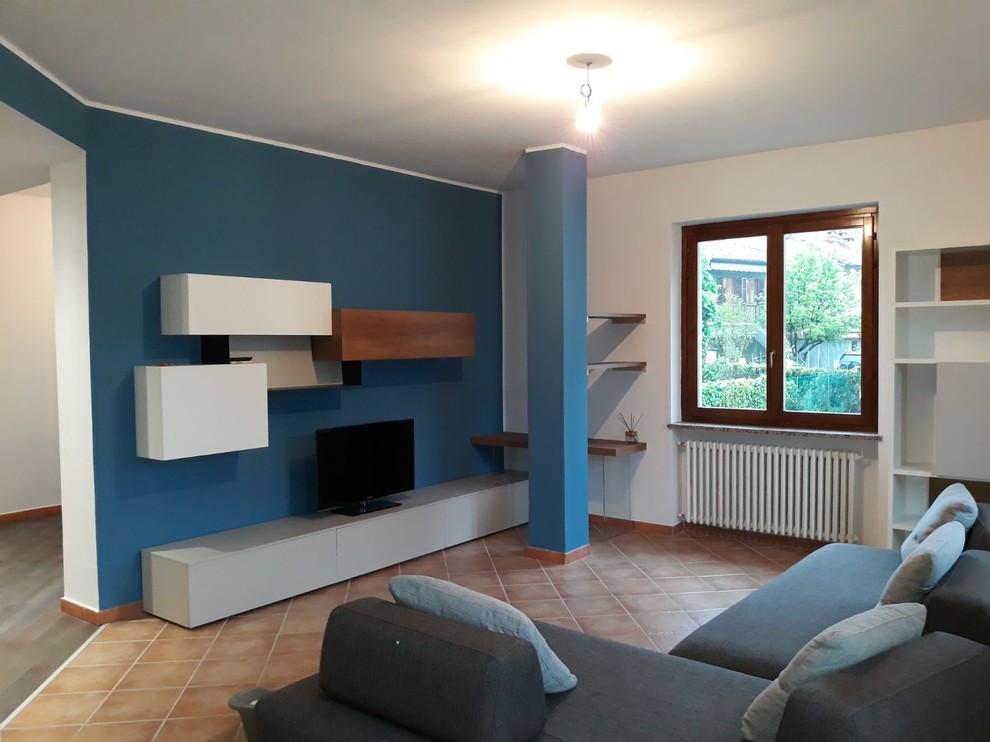 Идея дизайна: открытая гостиная комната среднего размера в современном стиле с синими стенами, полом из терракотовой плитки, мультимедийным центром и розовым полом