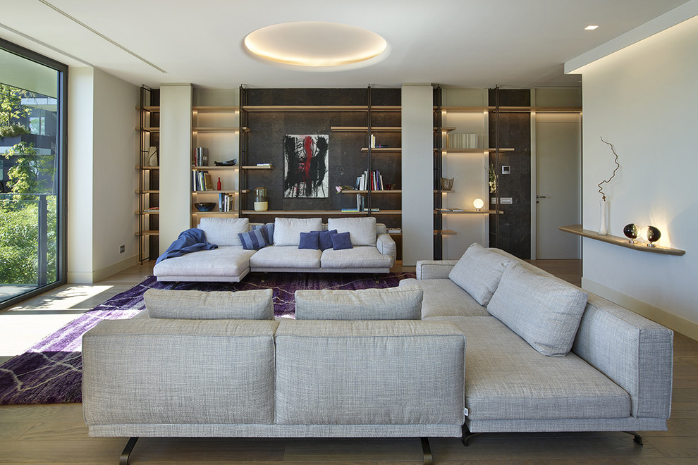 Idee per un ampio soggiorno design aperto con libreria, pareti bianche e pavimento in legno massello medio