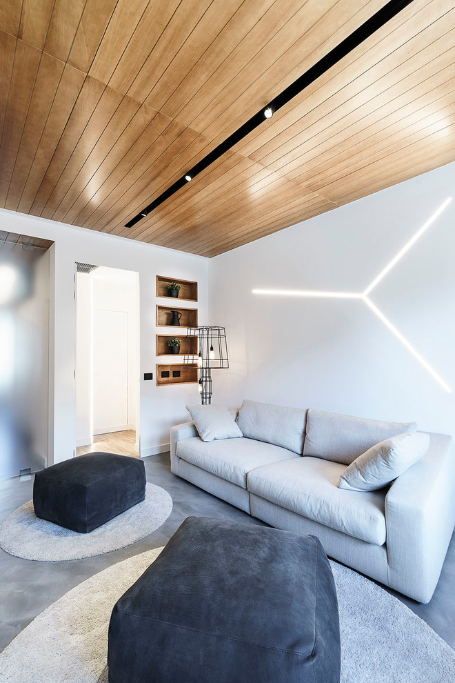 Modelo de sala de estar con rincón musical abierta contemporánea pequeña sin chimenea con paredes blancas, suelo de cemento, televisor colgado en la pared y suelo gris