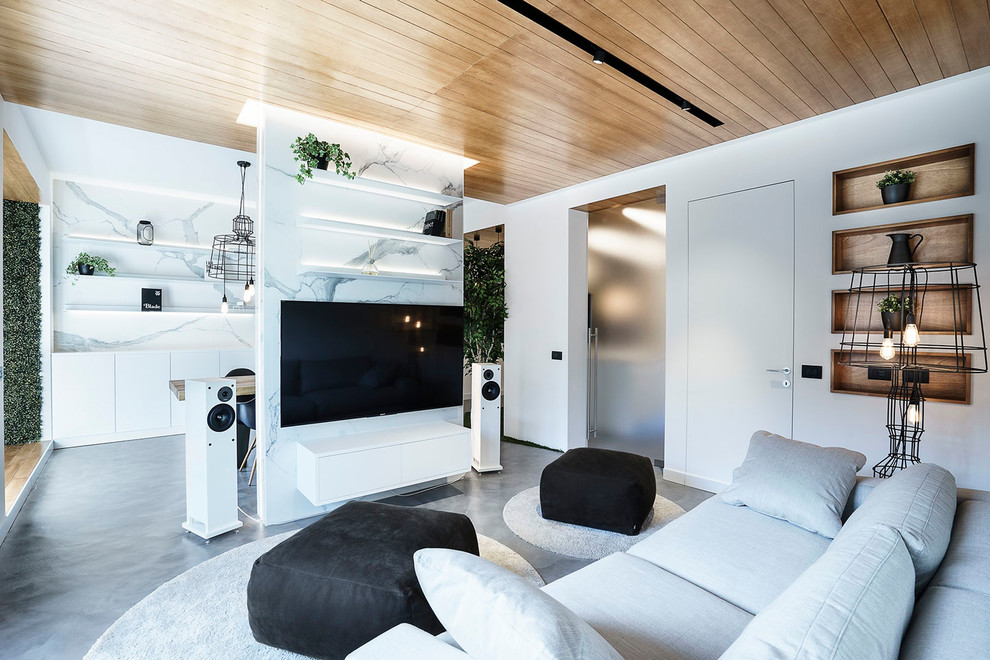 Стильный дизайн: маленькая открытая гостиная комната в современном стиле с белыми стенами, бетонным полом, серым полом, музыкальной комнатой и телевизором на стене без камина для на участке и в саду - последний тренд