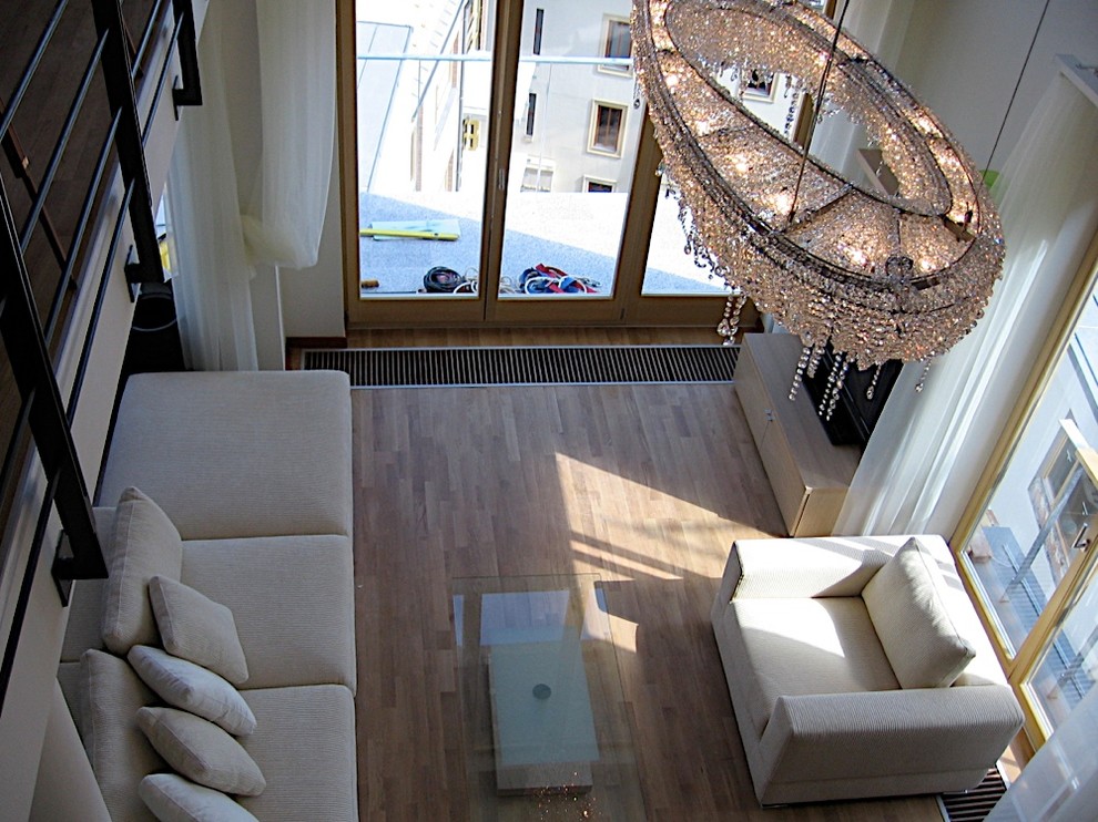 Esempio di un ampio soggiorno contemporaneo aperto con pareti bianche, pavimento in laminato e pavimento beige
