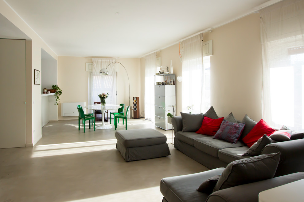 Пример оригинального дизайна: большая открытая гостиная комната в современном стиле с бетонным полом, серым полом и розовыми стенами без телевизора