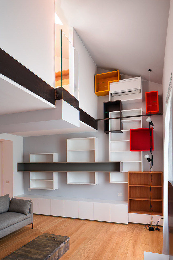 Источник вдохновения для домашнего уюта: двухуровневая гостиная комната среднего размера в современном стиле с с книжными шкафами и полками, серыми стенами и светлым паркетным полом