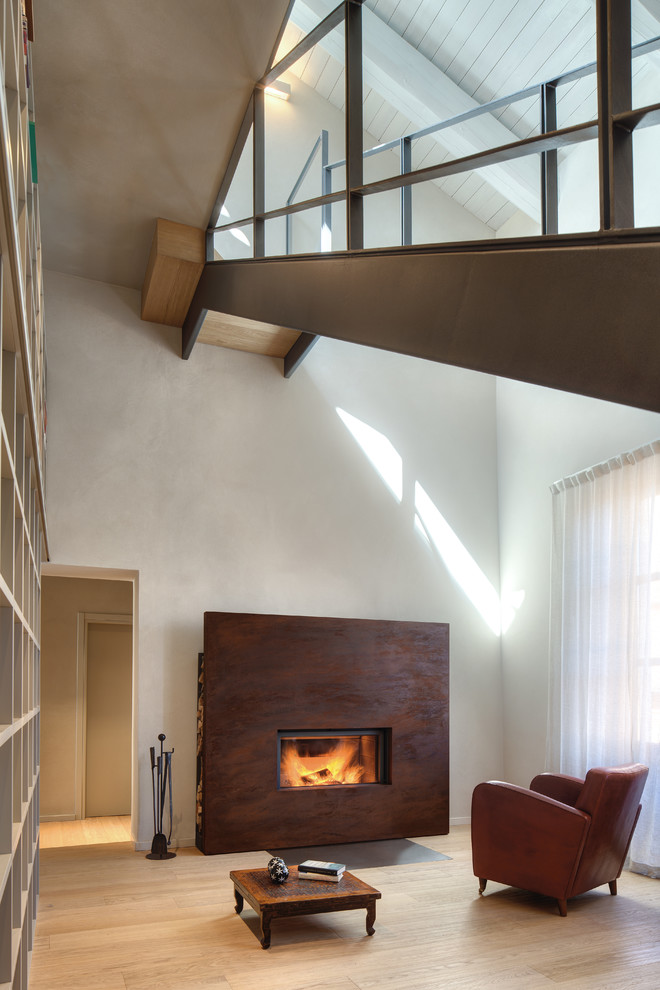 Modelo de salón abierto minimalista grande con paredes blancas, suelo de madera clara, chimenea lineal y marco de chimenea de metal
