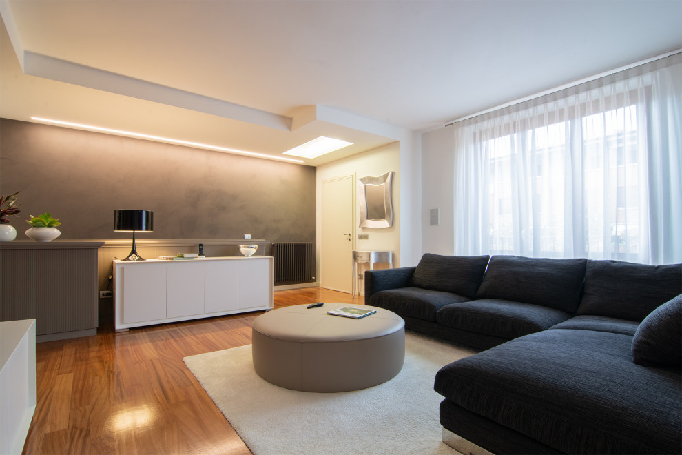Mittelgroßes, Repräsentatives, Offenes Modernes Wohnzimmer mit brauner Wandfarbe, gebeiztem Holzboden, TV-Wand und Tapetenwänden in Florenz