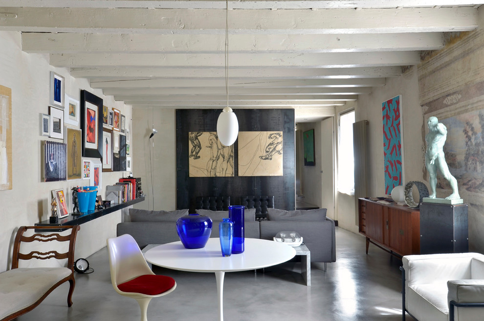 Ejemplo de salón cerrado ecléctico de tamaño medio sin chimenea y televisor con paredes beige, suelo de cemento y suelo gris