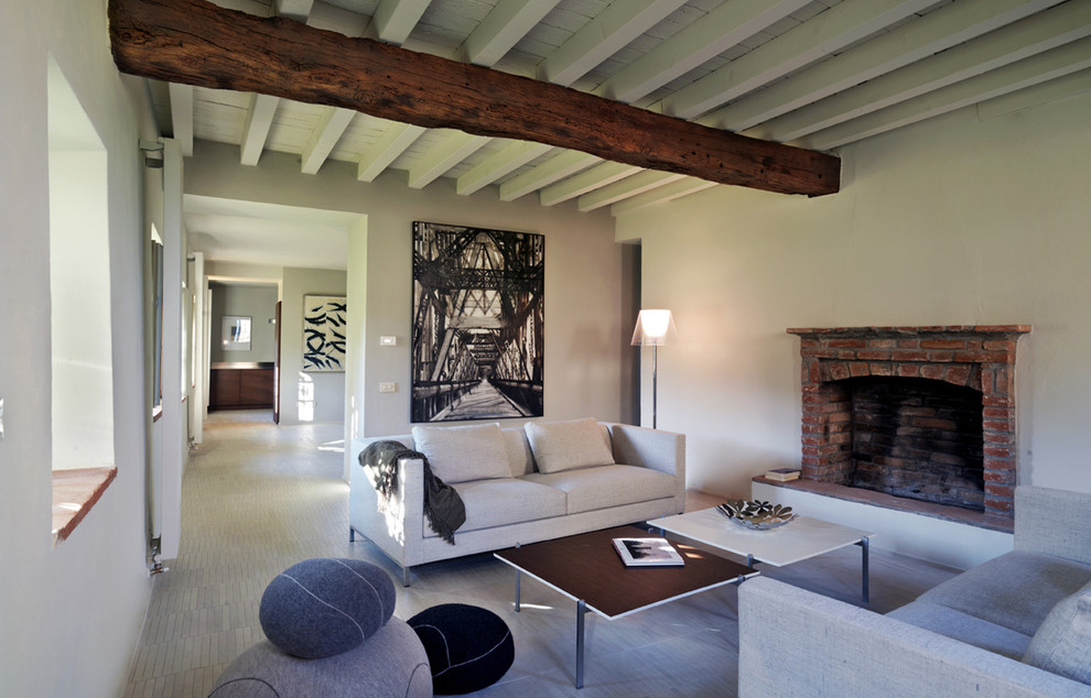 Exemple d'un grand salon tendance ouvert avec une salle de réception, un mur gris, une cheminée standard, un manteau de cheminée en brique et parquet clair.