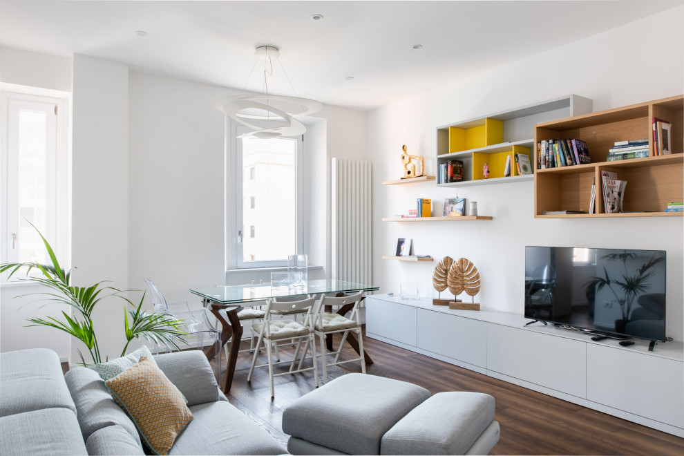 Immagine di un soggiorno design di medie dimensioni e aperto con pareti bianche, pavimento in legno massello medio, TV autoportante e pavimento marrone