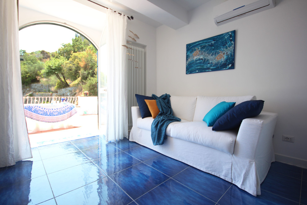 Inspiration pour un salon marin avec un mur blanc, un sol en carrelage de céramique et un sol bleu.