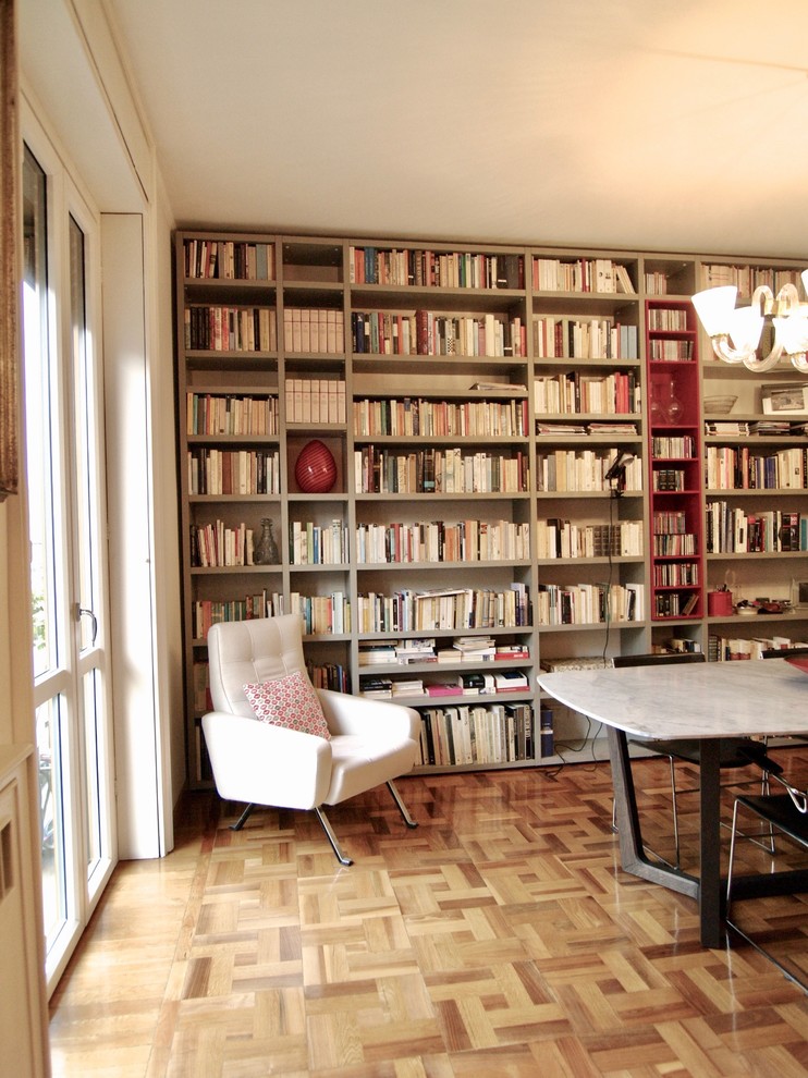Идея дизайна: открытая гостиная комната среднего размера в стиле фьюжн с с книжными шкафами и полками, серыми стенами, светлым паркетным полом и коричневым полом