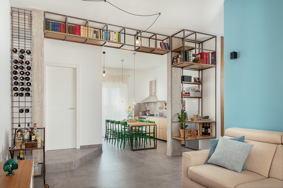 Свежая идея для дизайна: открытая гостиная комната в стиле лофт с с книжными шкафами и полками, синими стенами, полом из керамогранита и серым полом без камина - отличное фото интерьера