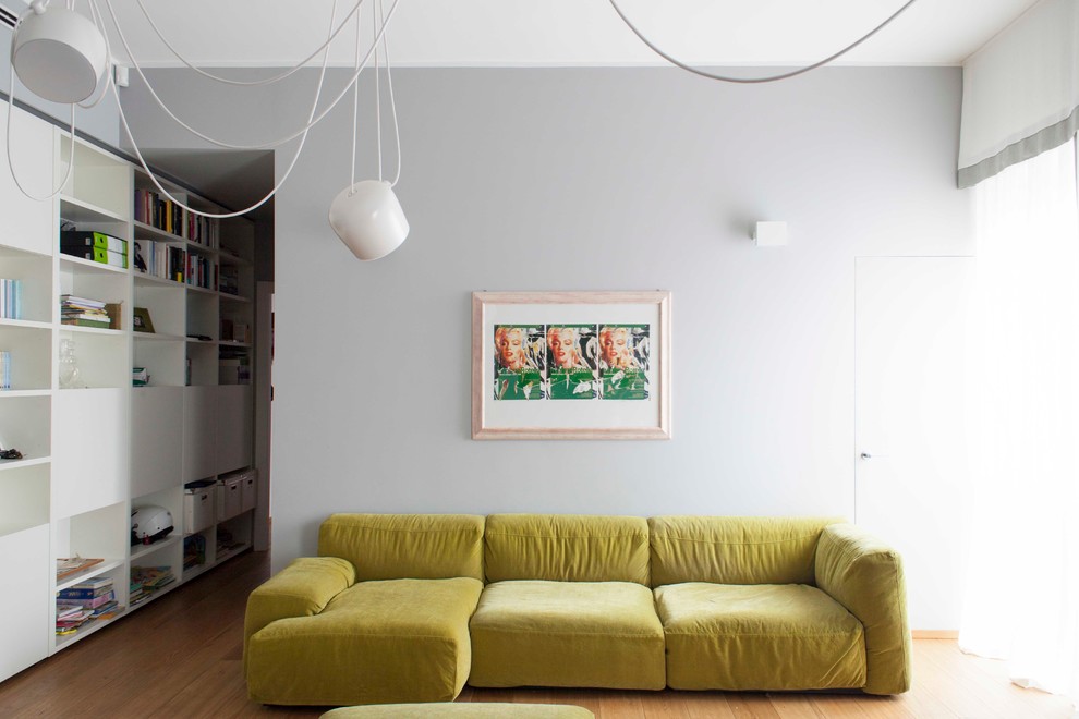 Cette image montre un salon design de taille moyenne et fermé avec un mur gris et un sol en bois brun.