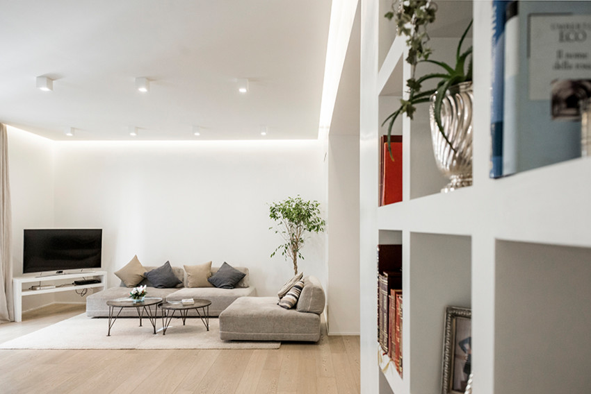 Foto di un grande soggiorno design aperto con pareti bianche, parquet chiaro, TV autoportante e pavimento marrone