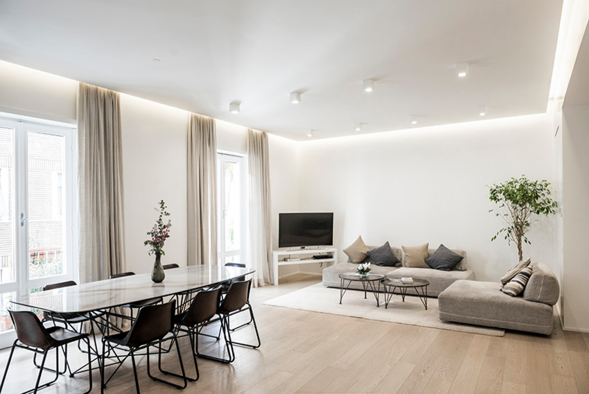 Esempio di un grande soggiorno contemporaneo aperto con pareti bianche, parquet chiaro, TV autoportante e pavimento marrone