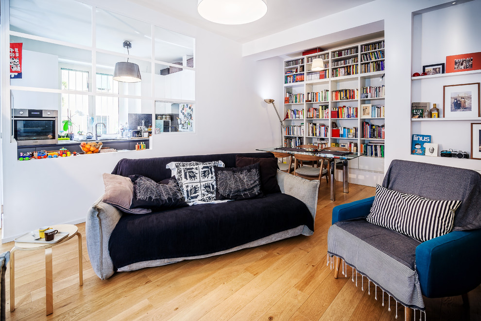 Ispirazione per un grande soggiorno minimal aperto con libreria e parquet chiaro