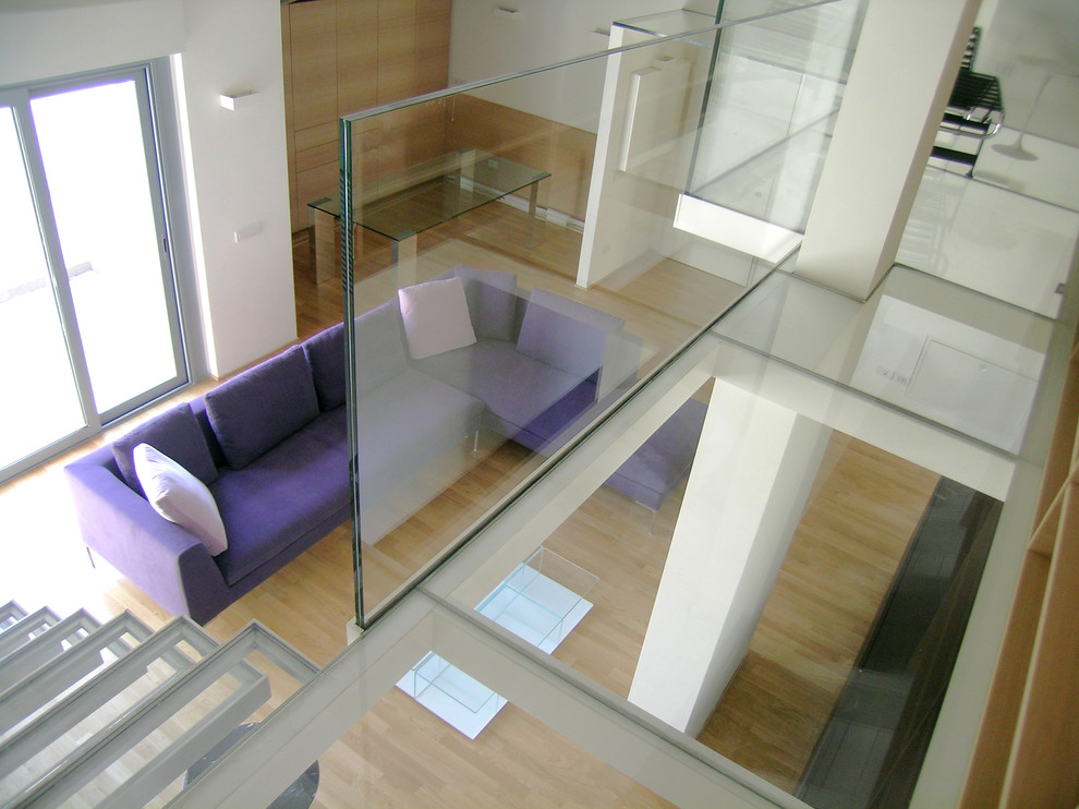 Foto di un ampio soggiorno contemporaneo stile loft con sala formale, pareti bianche, pavimento in legno massello medio e TV a parete